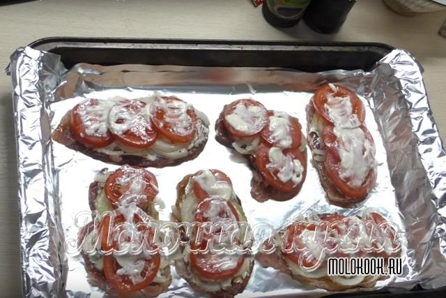 Выложены кусочки помидоров и лука