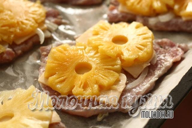 Ананасы и сыр разложены по мясу