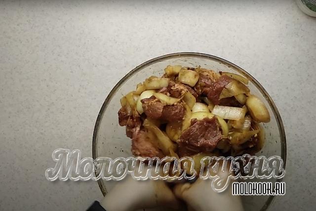 Перемешивание нарезанного мяса со специями и луковыми кольцами