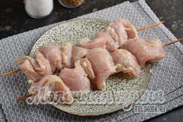 Кусочки курицы нанизаны на деревянные шпажки