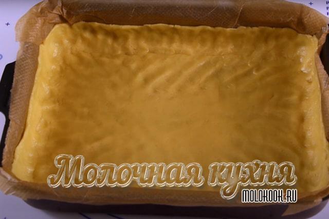 Песочное тесто распределено по форме для выпечки