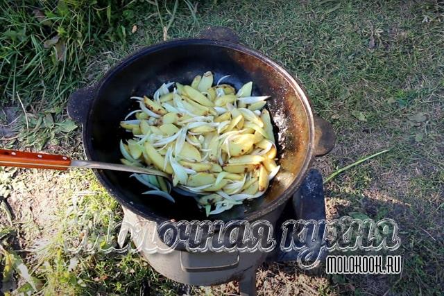 Лук добавлен и перемешан с картофельными ломтиками